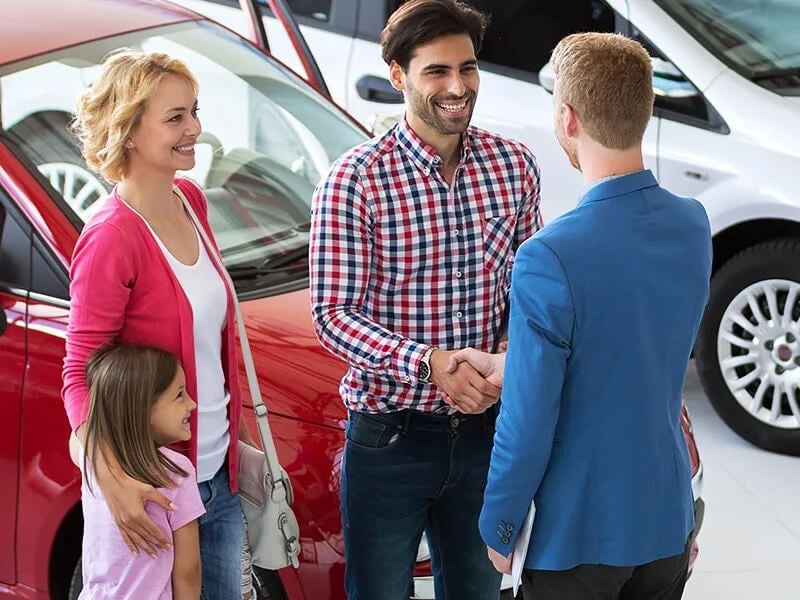 happy family buying car from dealer
